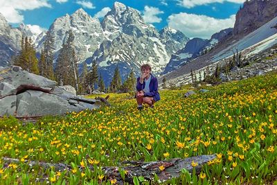 Man and yellow flowering plants on field