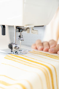 Midsection of woman using sewing machine