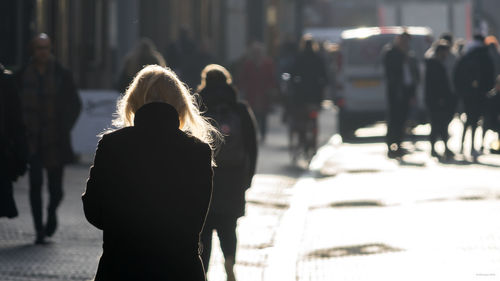 Rear view of women walking on street in winter