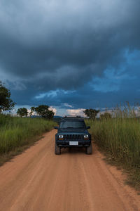 Car on road by land against sky