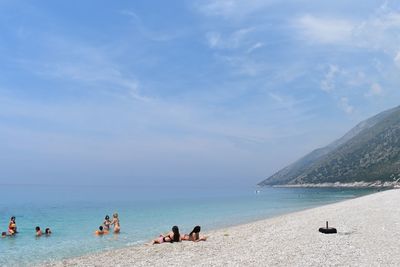 People on beach against sky