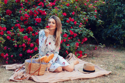 Portrait of young woman sitting on plant