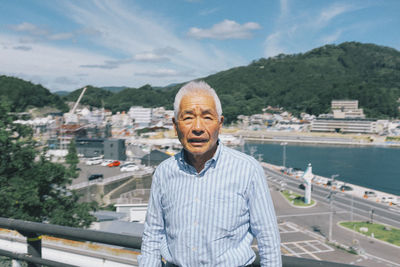 Portrait of smiling man standing against cityscape