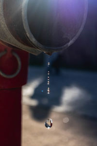 Close-up of water drop falling from faucet
