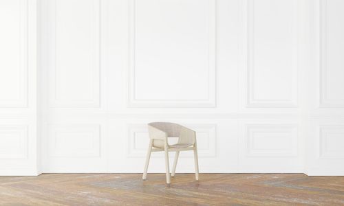 Empty chair against white wall