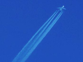 Low angle view of vapor trail against blue sky