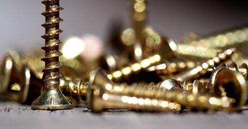 Close-up of golden screws on table