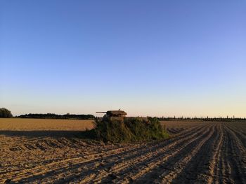 Scenic view of agricultural field against clear sky. old tank