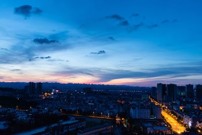 High angle view of illuminated buildings against sky at dusk