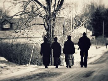 Rear view of people walking on road