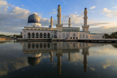 Kota kinabalu city mosquewith reflection on lake during sunrise