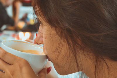 Close-up portrait of a woman drinking coffee