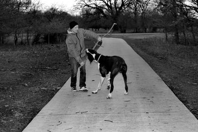 Full length of man with dog on road