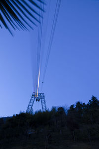 Low angle view of telephone pole against clear blue sky