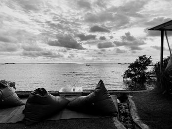 Man lying down on beach against sky