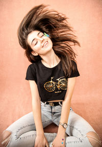 Beautiful young woman sitting on bed