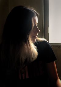 Side view of woman looking away at home