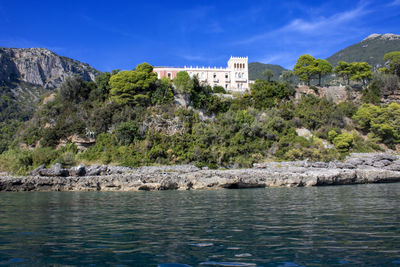 Scenic view of lake by buildings against blue sky