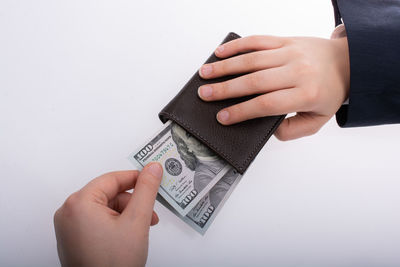 Close-up of woman holding hands over white background