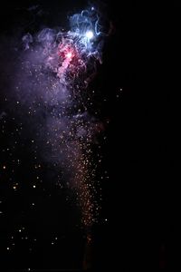 Low angle view of firework display at night