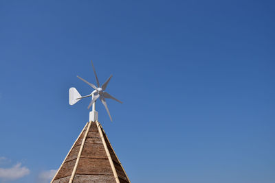 Low angle view of windmill against clear blue sky