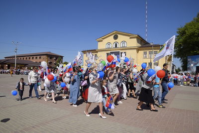 People on street against sky in city