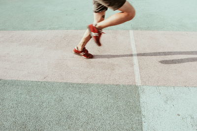 Low section of man running on track