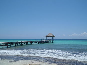 Lifeguard hut on beach against clear blue sky
