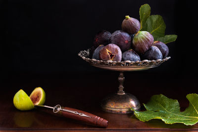 Close-up of figs on table against black background