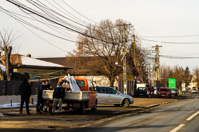 Vehicles on road against sky in city