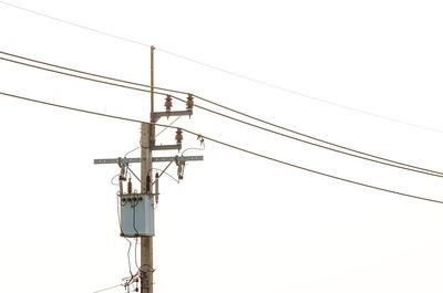 Low angle view of electricity pylon against clear sky