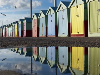 Beach houses reflecting on puddle