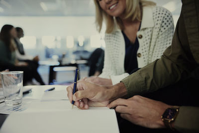 Man signing document during meeting in lobby