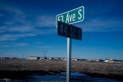 Signboards on street against sky during winter