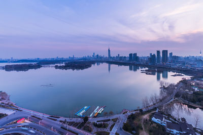 High angle view of river and buildings against sky during sunset