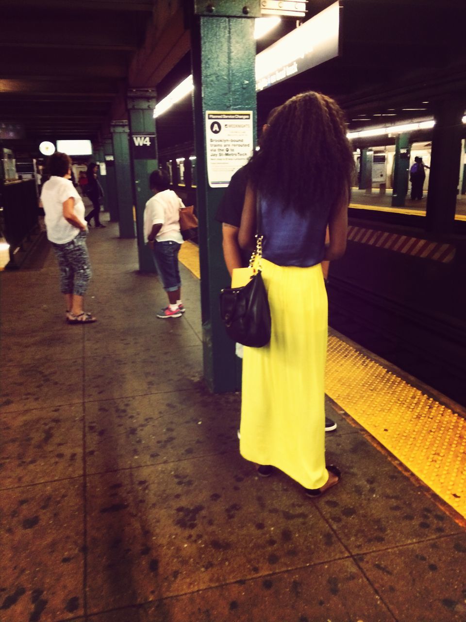 lifestyles, railroad station platform, casual clothing, full length, leisure activity, transportation, public transportation, rear view, railroad station, indoors, person, city life, travel, togetherness, incidental people, standing, passenger