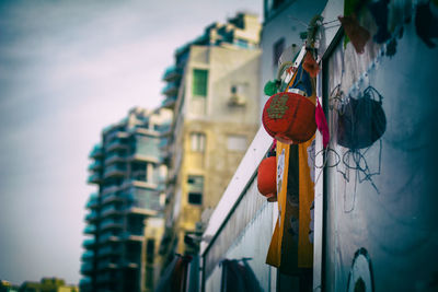Low angle view of lanterns hanging by building against sky