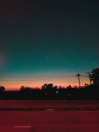 Scenic view of silhouette field against clear sky at night