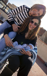 Portrait of smiling family sitting outdoors