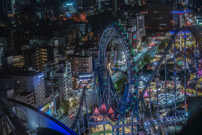 Illuminated ferris wheel in city at night