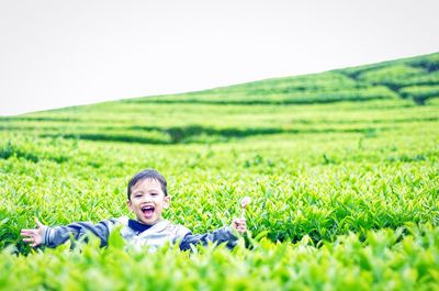Portrait of happy boy standing in farm against clear sky at kebunteh
