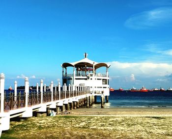 Built structure on beach against blue sky