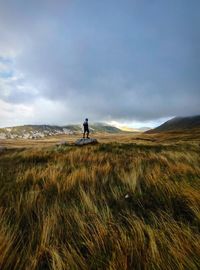 Man standing on field against sky