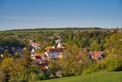 High angle view of trees and houses on field against sky