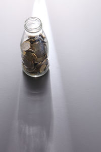 High angle view of coins in bottle on table