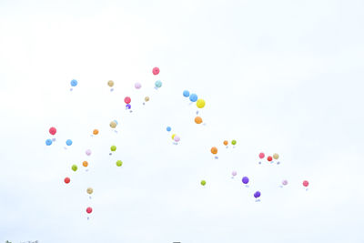 Low angle view of balloons against sky