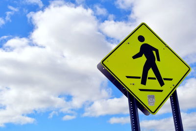 Low angle view of sign board against cloudy sky