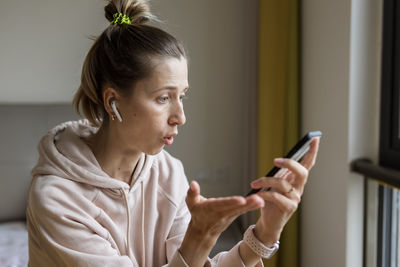 Young woman using mobile phone at home