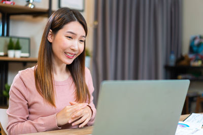 Young woman using laptop at home