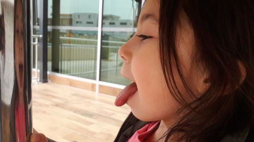 Close-up of girl sticking out tongue